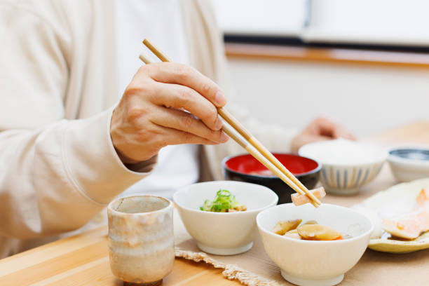 istock Man holding chopsticks with meal 1494150816
