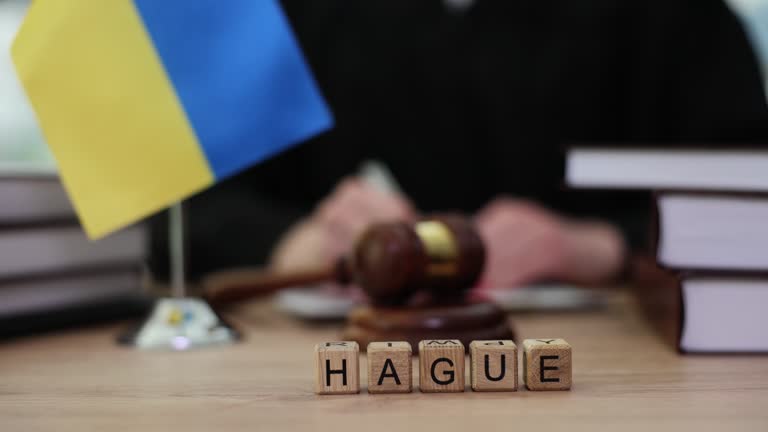 Word hague with flag of ukraine and judges in courtroom closeup