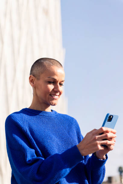 istock confident woman in blue sweater using mobile phone 1494155213
