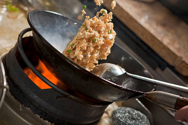 Cooking asian stir fry in wok Closeup of steaming food being cooked in wok chinese cuisine fried rice asian cuisine wok stock pictures, royalty-free photos & images