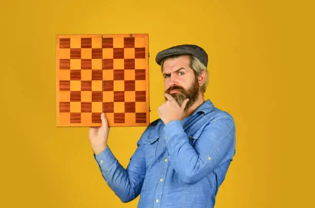 Enjoy tournament. Strategy concept. Chess competition. Board game. Thoughtful bearded man play chess. Chess figure. Intellectual game. Grandmaster player. Chess lesson. Cognitive development.