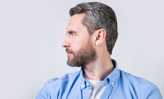 profile of caucasian casual man with stubble in studio. photo of caucasian man wear casual. caucasian man wearing casual shirt. caucasian man in casual style isolated on grey background.