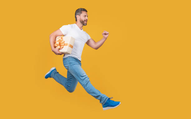 istock Active courier man running with gift box. Fast courier delivery. Courier service, copy space 1494164199