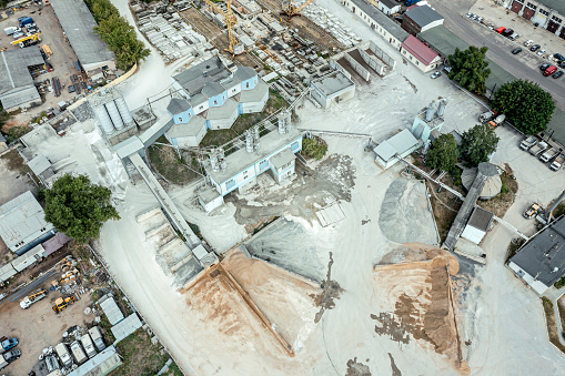 concrete mixing plant. concrete batching plant storage yard is filled with various piles of sand and gravel. aerial overhead view.