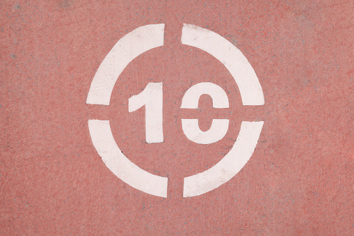 Number 10 sign on a red asphalt, cycling lane.