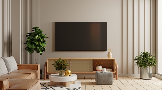 Empty living room mockup a TV wall mounted with leather sofa in living room with cream color wall.3d rendering