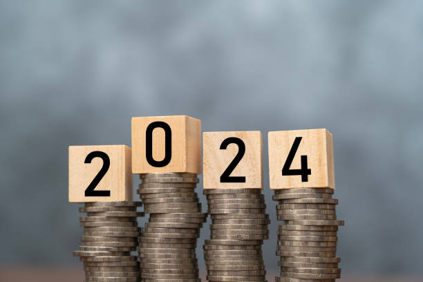 Wooden block cube from 2024 on coins stacking for setup objective target business cost and budget planing of new year concept.