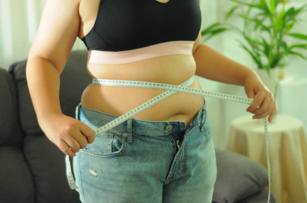 istock Fat diet and scale feet standing on electronic scales for weight control. 1494179053