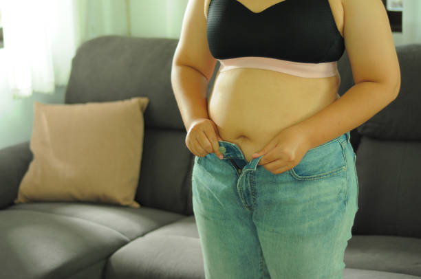 istock Fat diet and scale feet standing on electronic scales for weight control. 1494179083