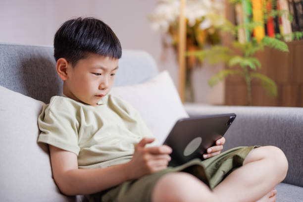 istock boy playing games on a digital tablet at home 1494179547