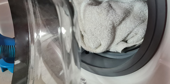 White linen towel in the washing machine closeup