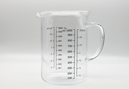 Empty glass measuring cup isolated on white background