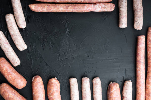 istock Assorted raw homemade sausages, frame concept, flat lay with space for text, on black background 1494180834