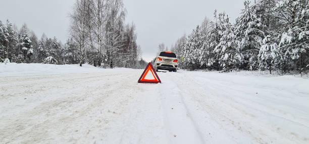 istock Winter auto transport and red warning triangle with broken car 1494180964