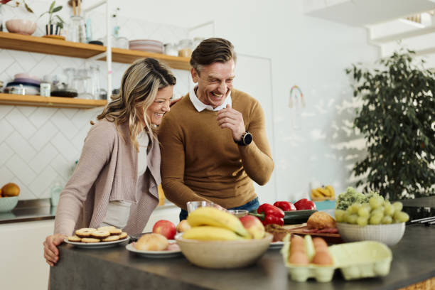 istock Cheerful couple preparing food in the kitchen. 1494183378