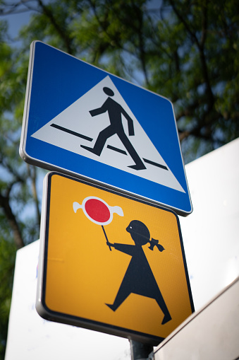 Sign indicating pedestrian crossing site at a road in a sunny day - run over risk