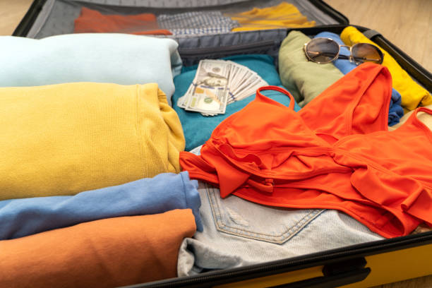 istock Folded women's clothing, passports with dollars in a suitcase. 1494187735