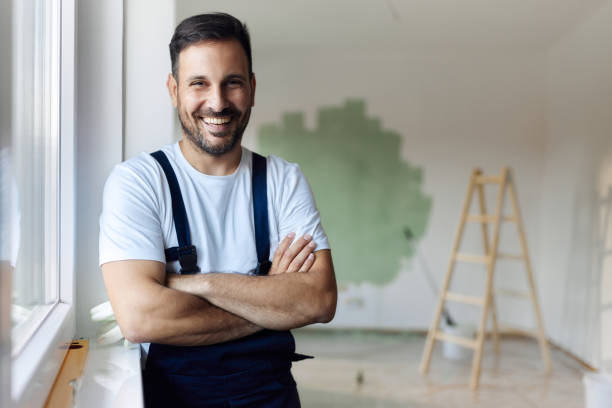istock Happy house painter with crossed by the window. 1494188752
