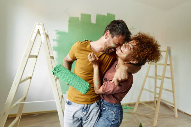 istock Cheerful couple embracing while painting their new home. 1494189221