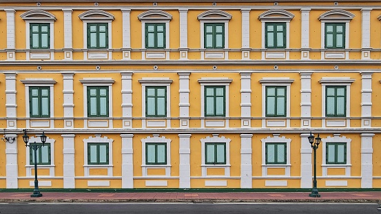 Multiple closed windows on yellow large building wall