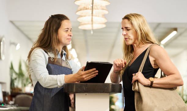 istock Owner with a tablet helping a customer shopping in her store 1494199334