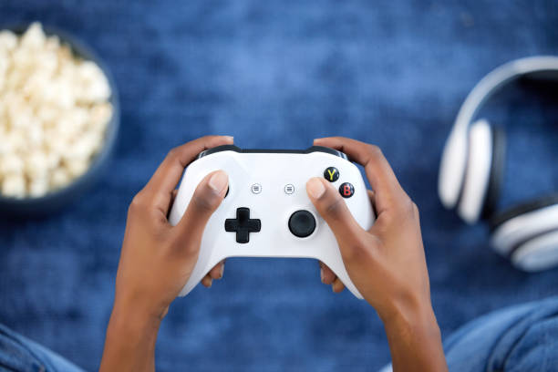 Hands, video games and person playing online game on home with popcorn for gaming, gamepad and relax. Gamer woman console, joystick or control for esports, streaming and above cyber competition Hands, video games and person playing online game on home with popcorn for gaming, gamepad and relax. Gamer woman console, joystick or control for esports, streaming and above cyber or digital world 4k gaming stock pictures, royalty-free photos & images