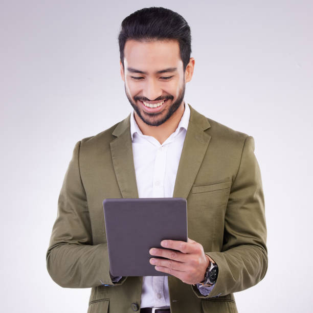 istock Business man, tablet and smile in studio for internet, communication and network connection. Entrepreneur male online for mobile app networking, social media or research on investment or sales 1494204838