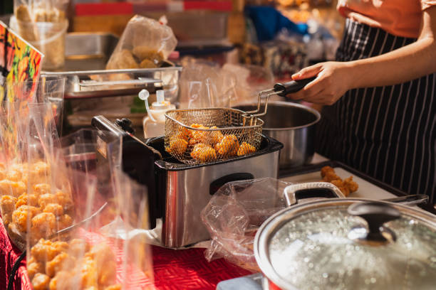 Female chef deep fried meat ball in kitchen.