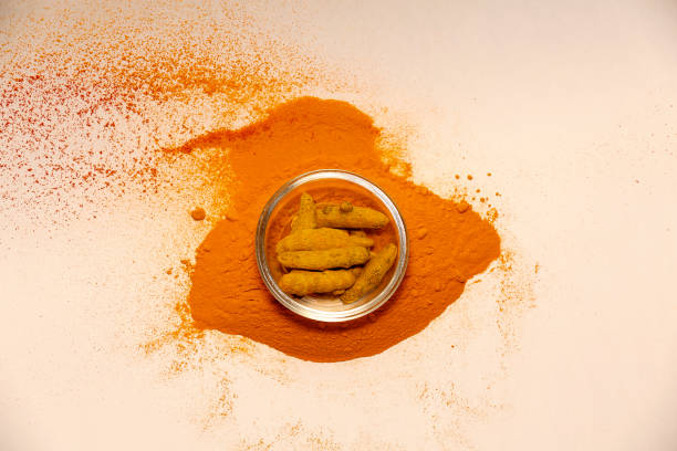 istock Turmeric roots in glass bowl and powder table top view 1494206252