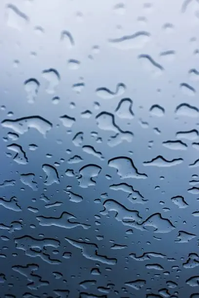 Drops of rain on the sunroof in the car.