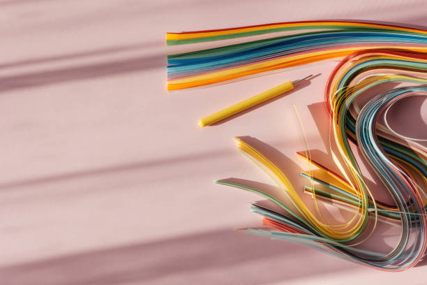 istock Paper and quilling tools on a pink background with space for text and design. 1494208487