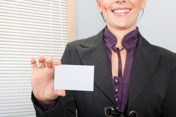 Young business girl in office holding blank card