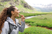 Hiker eating cereal bar in a valley