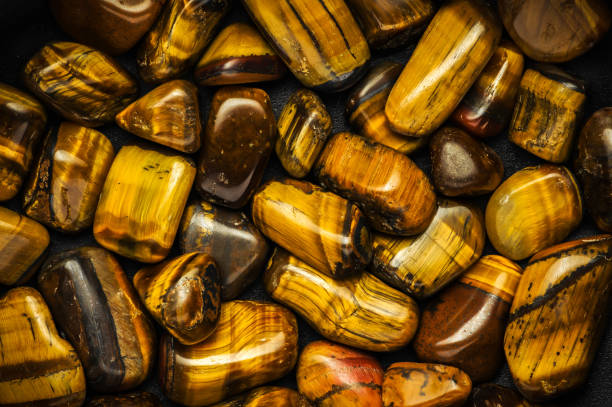 Tiger's eye golden stone chips macro detail texture background. close-up polished semi-precious gemstone.