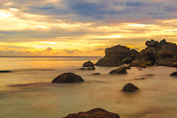 Beach Landscape with rock formation during sunrise on Sumurtiga beach, Sabang, Aceh, Indonesia. stock photo