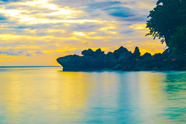 Beach Landscape with rock formation during sunrise on Sumurtiga beach, Sabang, Aceh, Indonesia. stock photo