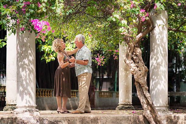 Happy senior couple dancing latin american dance for fun Active retired people having fun, happy old man and woman dancing latin american dance in patio salsa music photos stock pictures, royalty-free photos & images