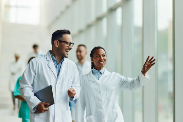 Happy doctors walking through hallway of a hospital.