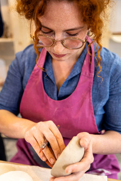 istock Woman working in pottery studio workshop making bowl from clay. 1494220996