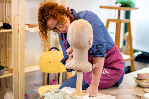 female sculptor working in pottery studio workshop sculpting human head. - sculpture clay human face human head imagens e fotografias de stock
