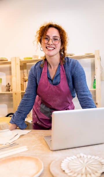 istock Female business owner using laptop in pottery studio workshop. 1494221051