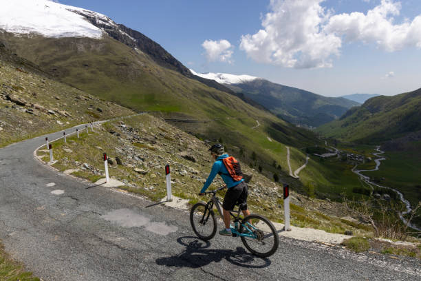 istock Young woman rides e-bicycle on mountain road 1494221470