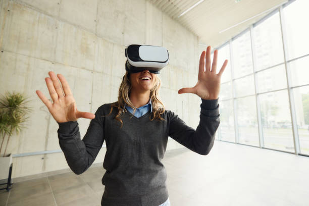 istock Happy businesswoman using VR headset in a hallway. 1494221595