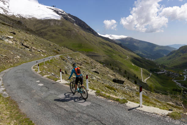 istock Young woman rides e-bicycle on mountain road 1494221682