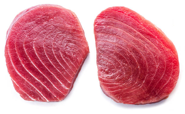 istock Two raw tuna fish steaks isolated on white background. 1494223408