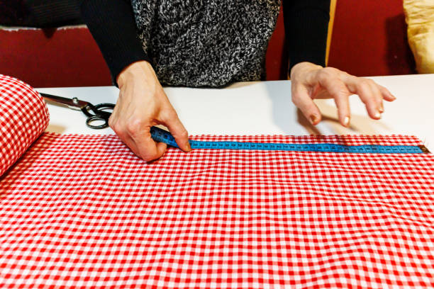 istock A woman tailor is working in the workshop using scissors and a ruler for preparing material. 1494223502