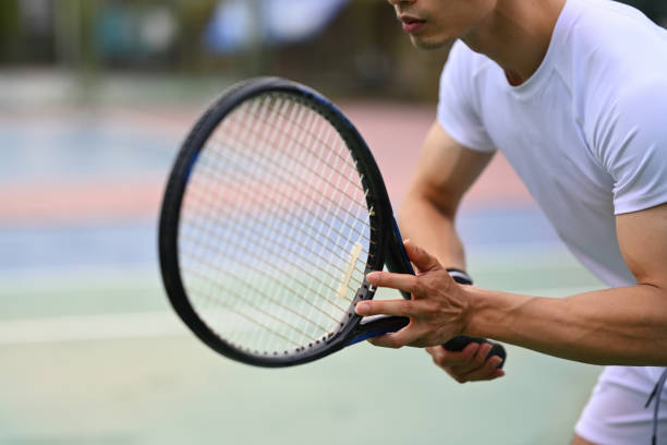istock Male tennis player focused in ready position to receive a serve, practicing for competition on a court. 1494223546