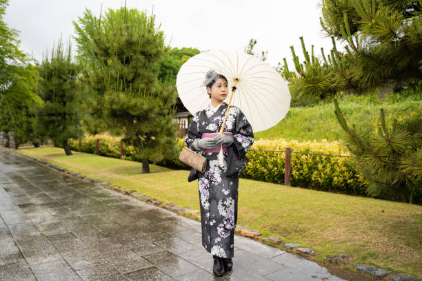 雨の日に伝統的な着物を着た美しい女性の姿。