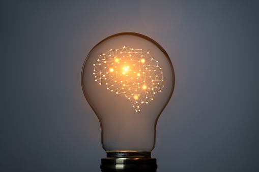 Artificial intelligence concept with brain symbol and glowing light bulb. This file is cleaned and retouched.