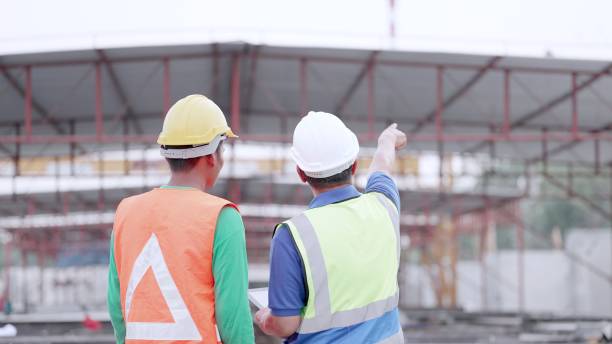 istock Engineer or contractors and partners in construction business together to plan and agreements procedures for the construction of buildings or housing projects. Team contractor in safety uniform working at construction site. 1494226338